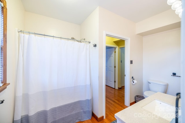 bathroom featuring vanity, toilet, hardwood / wood-style flooring, and walk in shower