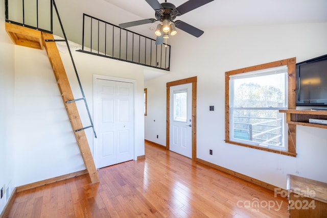 foyer with high vaulted ceiling, wood-type flooring, and ceiling fan