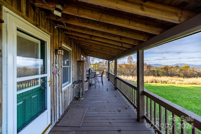 wooden deck featuring a yard and a mountain view