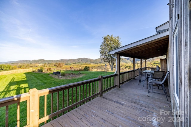 deck with a mountain view and a lawn