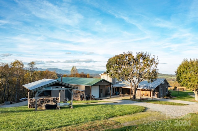 ranch-style house featuring a mountain view, a front lawn, and a garage