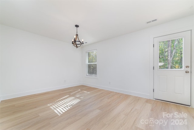 interior space with a notable chandelier, a wealth of natural light, and light wood-type flooring