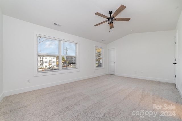 carpeted spare room with ceiling fan and lofted ceiling