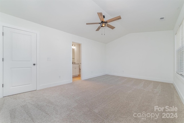 unfurnished bedroom with ceiling fan, lofted ceiling, light colored carpet, and ensuite bathroom