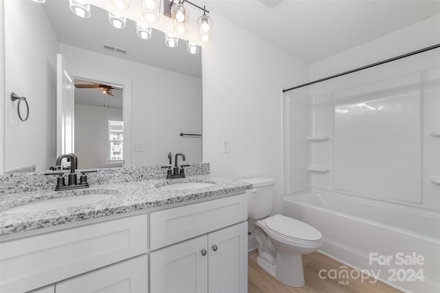 full bathroom featuring wood-type flooring, toilet, ceiling fan, shower / tub combination, and vanity