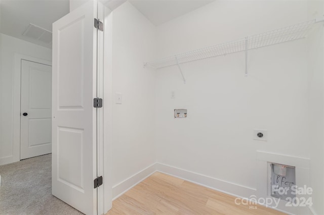 clothes washing area with hookup for an electric dryer, hardwood / wood-style floors, and washer hookup