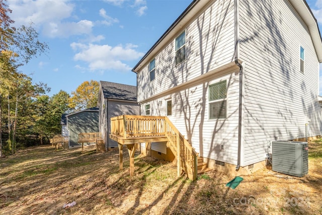 rear view of house with a wooden deck and central AC unit