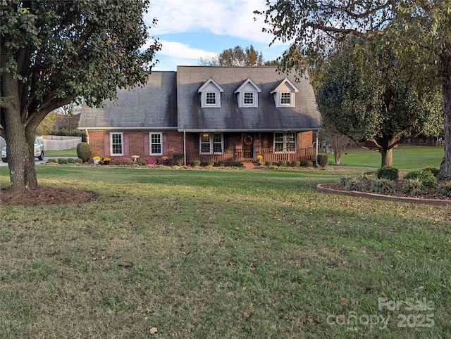 cape cod-style house with covered porch, a front lawn, and brick siding