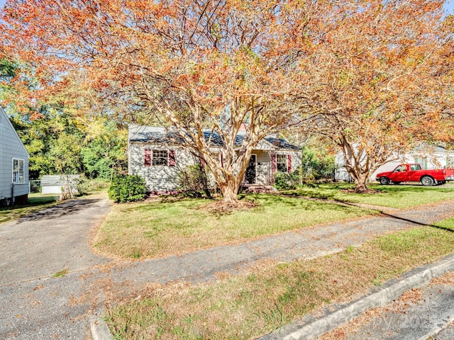 view of property hidden behind natural elements with a front lawn