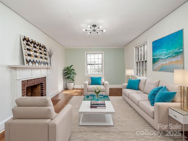 living room with a brick fireplace, hardwood / wood-style flooring, and a chandelier