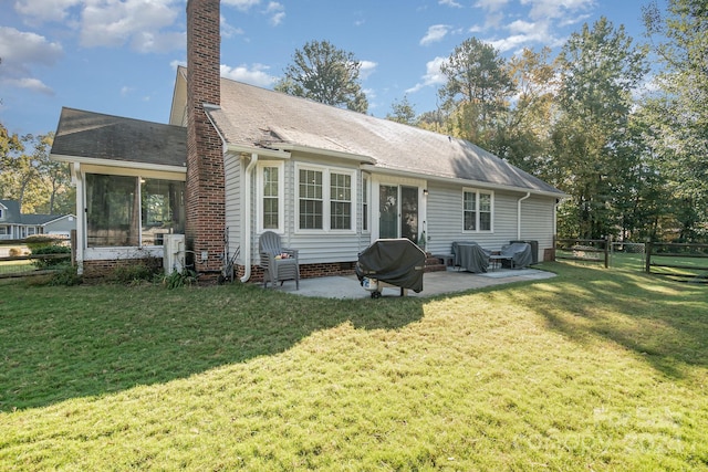 back of house featuring a yard, a patio area, and a sunroom