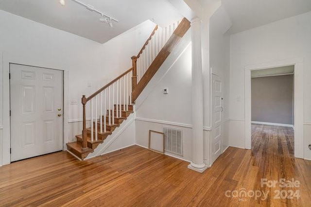 foyer entrance with hardwood / wood-style flooring and track lighting