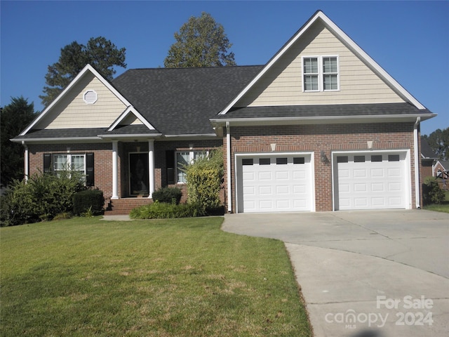 204 Par Dr, Henderson, NC 27536 - view of front of house with brick siding, concrete driveway, a front lawn, and a garage