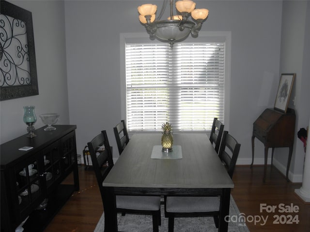 dining space with an inviting chandelier and dark hardwood / wood-style floors