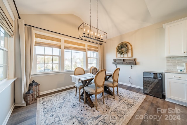 dining space with a chandelier, wine cooler, vaulted ceiling, and dark wood-type flooring