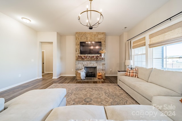 living room with a fireplace, dark hardwood / wood-style floors, and a notable chandelier