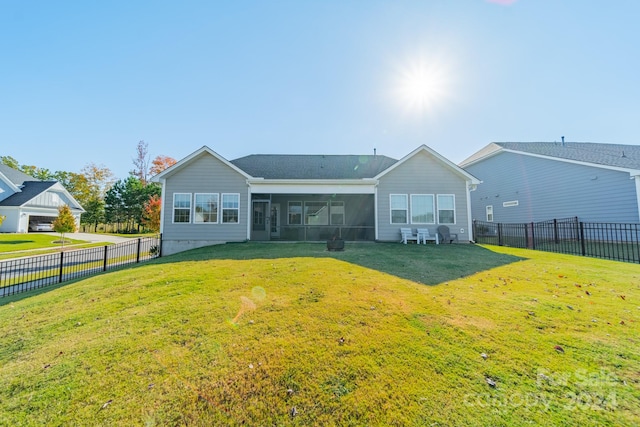 back of property featuring a sunroom and a lawn