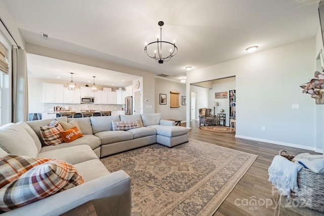 living room featuring a notable chandelier and dark hardwood / wood-style flooring