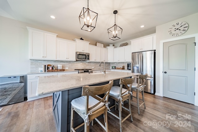 kitchen with light hardwood / wood-style floors, white cabinetry, sink, and appliances with stainless steel finishes