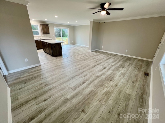 interior space featuring ceiling fan, light wood-type flooring, and ornamental molding