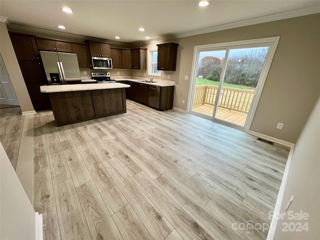 kitchen featuring stainless steel appliances, a kitchen island, and light hardwood / wood-style flooring