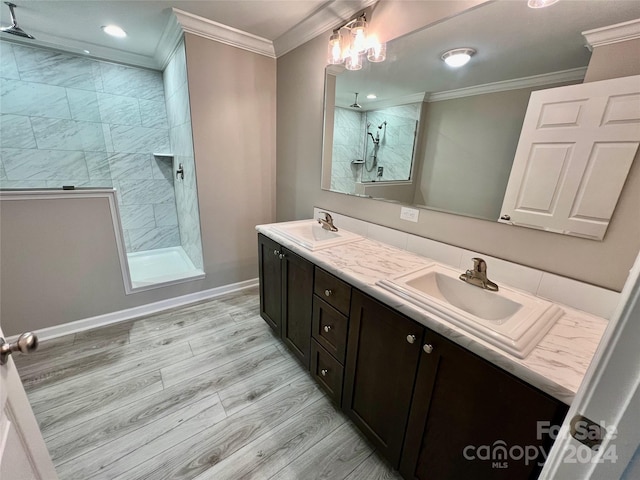 bathroom featuring vanity, crown molding, a tile shower, wood-type flooring, and a chandelier