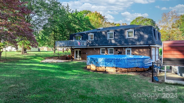 back of property featuring a yard and a covered pool