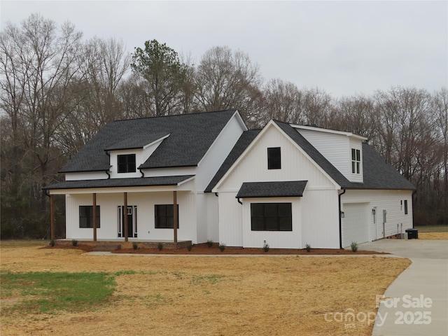 modern farmhouse featuring covered porch, driveway, and roof with shingles