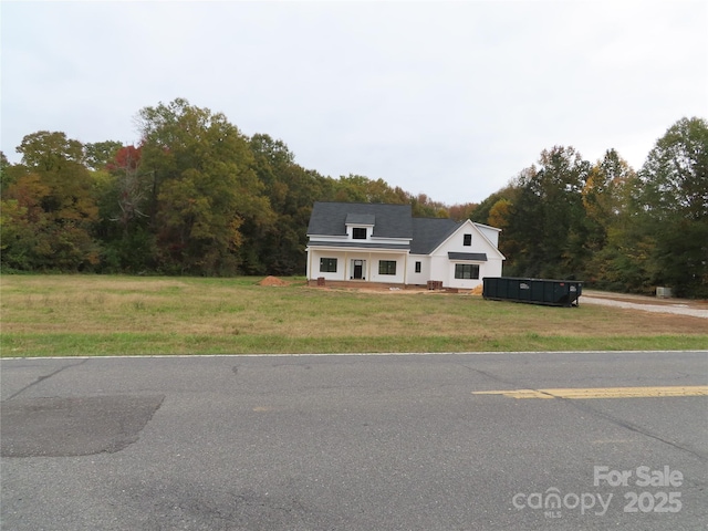 view of front of home with covered porch and a front lawn