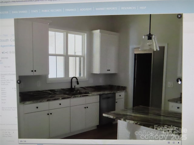 kitchen featuring white cabinetry, a sink, hanging light fixtures, and dishwashing machine