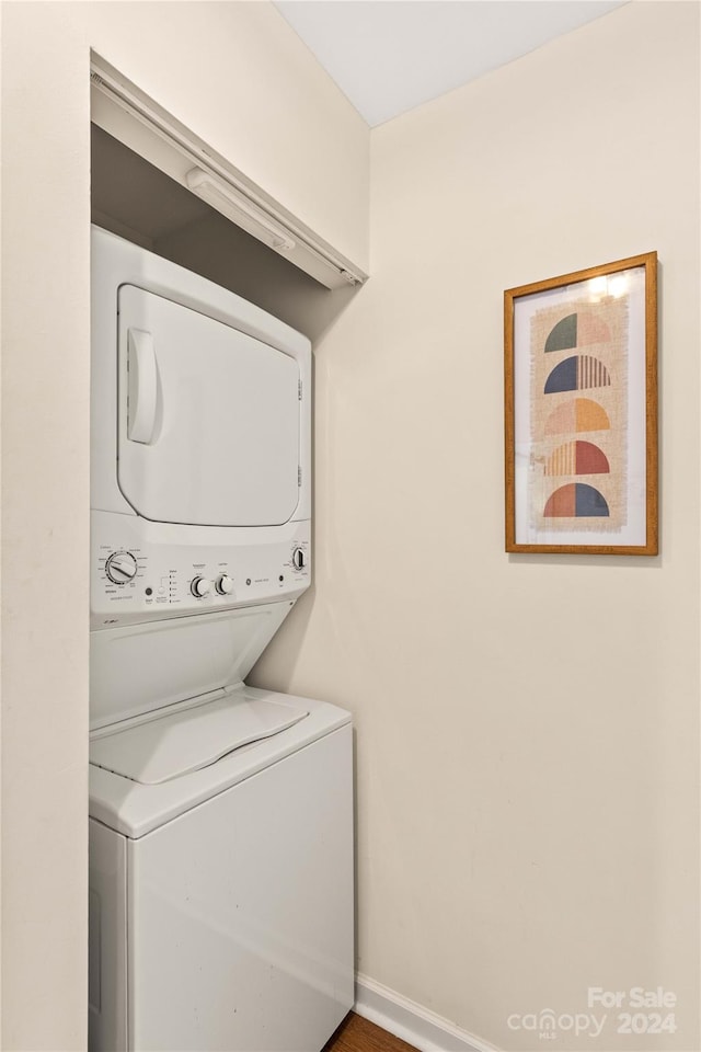 clothes washing area with stacked washer / dryer