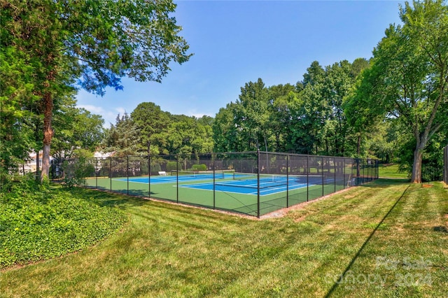 view of tennis court with a yard