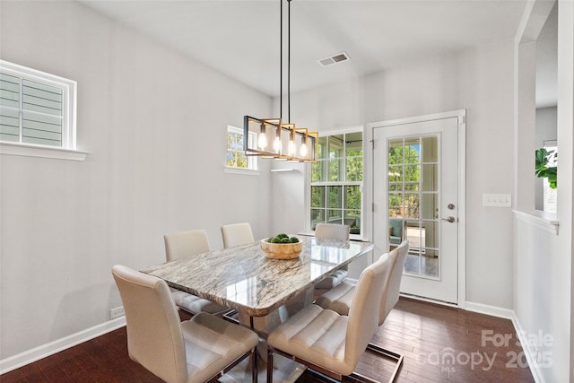 dining area featuring visible vents, baseboards, and dark wood-style floors