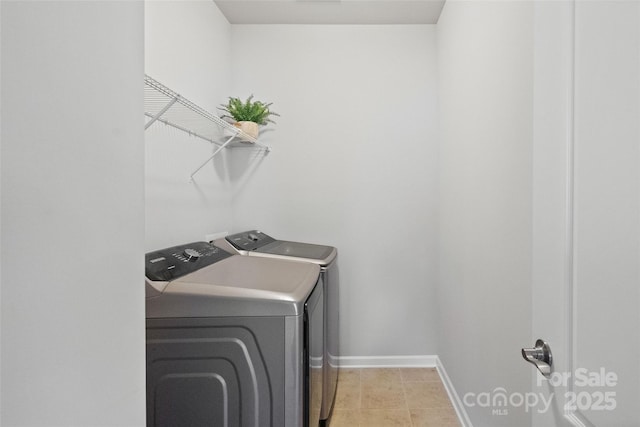 laundry area with laundry area, light tile patterned flooring, separate washer and dryer, and baseboards