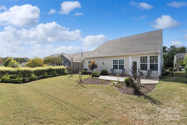 back of property with a patio area, fence, roof with shingles, and a lawn