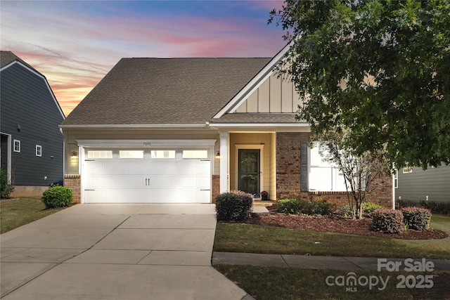 view of front of property with brick siding, board and batten siding, concrete driveway, roof with shingles, and an attached garage