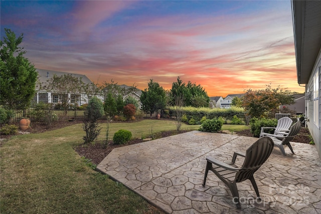 patio terrace at dusk with a lawn and fence