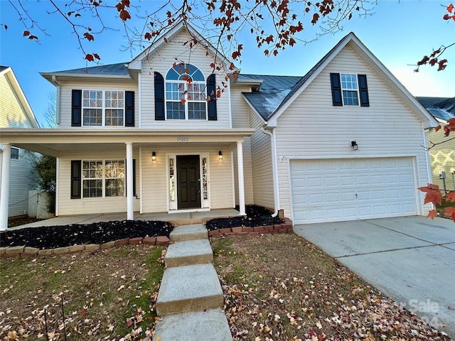 front facade featuring covered porch and a garage