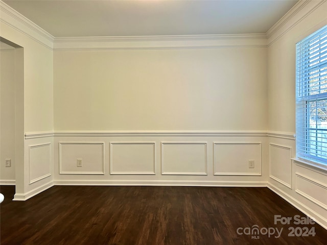 empty room featuring dark hardwood / wood-style flooring and ornamental molding