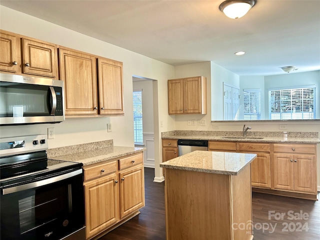 kitchen featuring a center island, sink, appliances with stainless steel finishes, and dark wood-type flooring