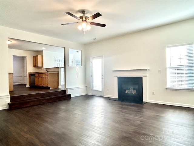 unfurnished living room featuring dark hardwood / wood-style floors and ceiling fan