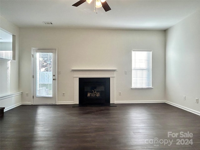 unfurnished living room with ceiling fan, dark hardwood / wood-style flooring, and a healthy amount of sunlight