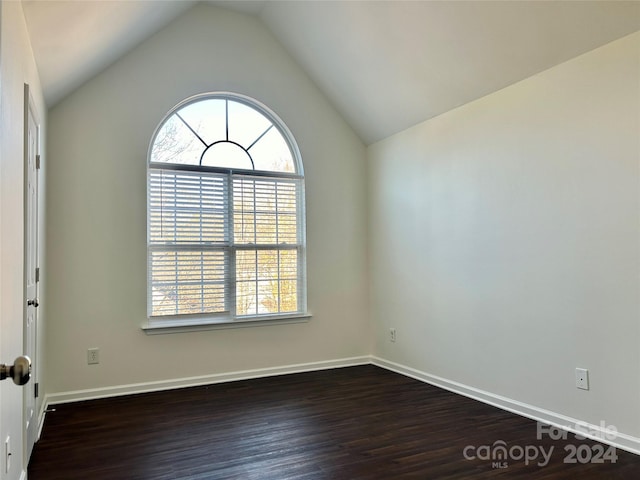 unfurnished room featuring dark hardwood / wood-style flooring and lofted ceiling