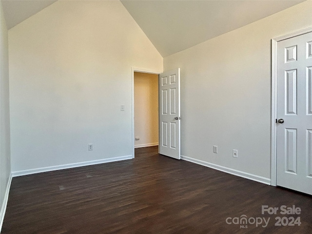 spare room with dark hardwood / wood-style floors and high vaulted ceiling