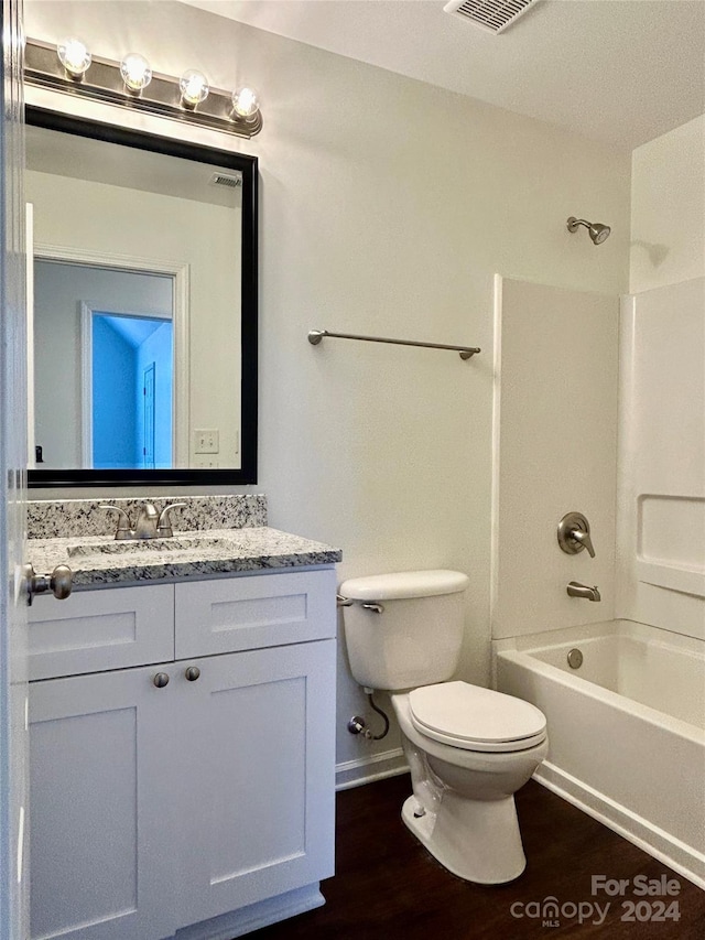 full bathroom with hardwood / wood-style flooring, vanity, toilet, and shower / tub combination