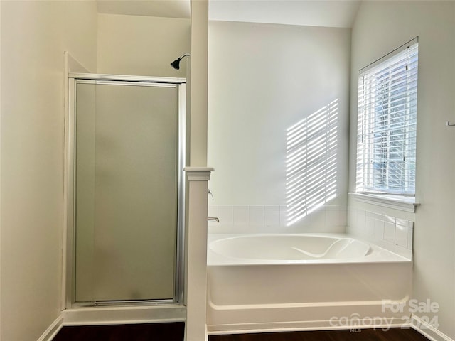 bathroom featuring hardwood / wood-style flooring and shower with separate bathtub