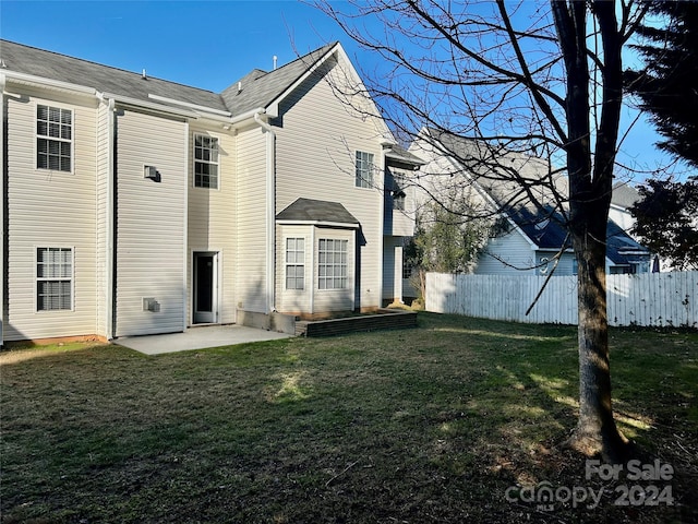 back of property with a lawn and a patio area