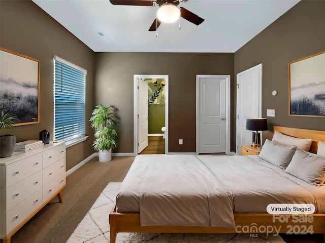 bedroom with carpet, ensuite bathroom, and ceiling fan