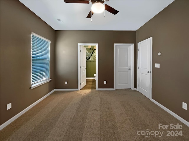 unfurnished bedroom featuring ceiling fan, carpet floors, and a walk in closet