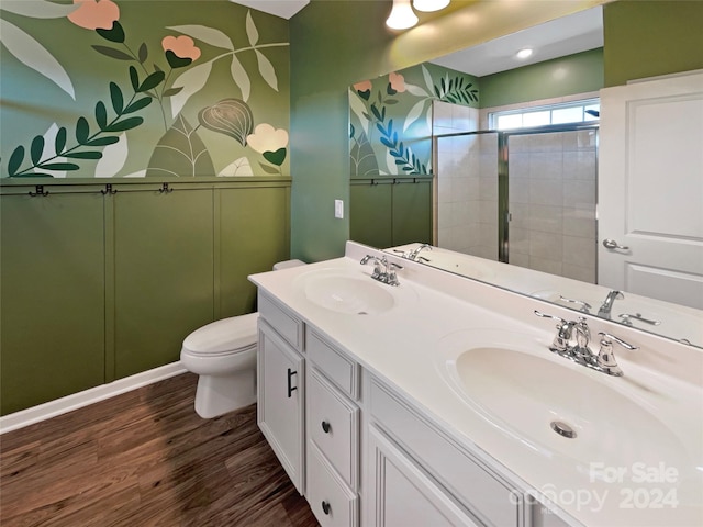 bathroom with vanity, toilet, hardwood / wood-style flooring, and tiled shower